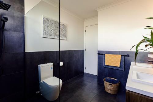 a bathroom with a toilet and a sink at Wamoon Retreat - Luxe House in Yanakie
