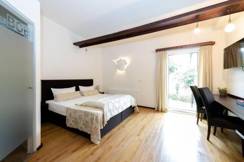 1 dormitorio con cama, escritorio y ventana en S'Matt Bob en Feldkirch