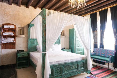 a bedroom with a canopy bed and a chandelier at Abraham Otel in Sanlıurfa