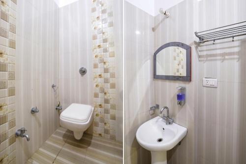 a bathroom with a toilet and a sink at FabHotel Raka Inn in Allahābād