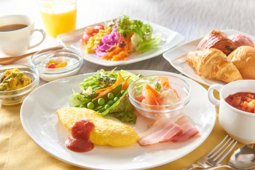stół z trzema talerzami jedzenia. w obiekcie Kobe Motomachi Tokyu REI Hotel w mieście Kobe