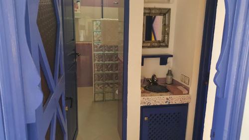 uma casa de banho com um lavatório e um chuveiro com um espelho. em belle maison vue sur mer em Oualidia