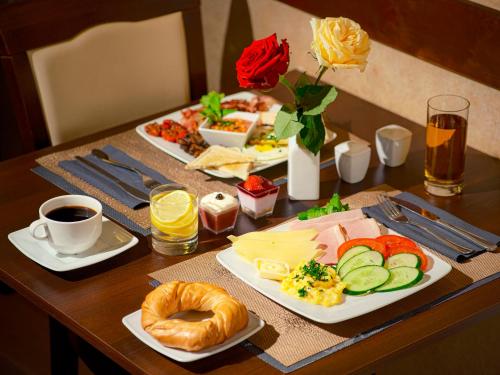 a table with two plates of breakfast food on it at Hotel Santi in Kraków