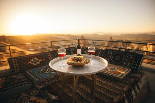 a table with two glasses of wine and a bowl of food at Harem Suites Cappadocia in Uchisar