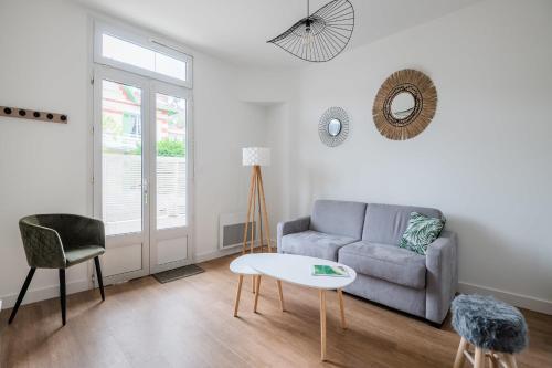 a living room with a couch and a table at A bright cocoon for a pleasant stay in Arcachon in Arcachon