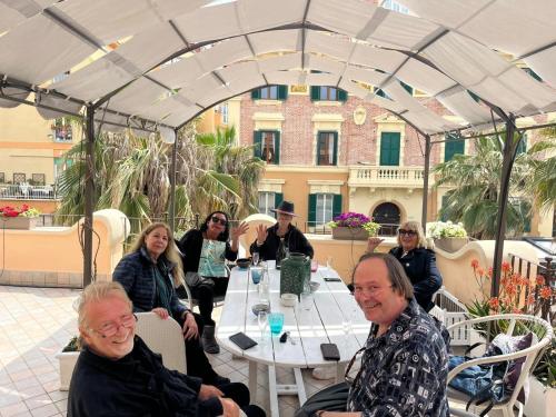 un groupe de personnes assises à une table sous une tente dans l'établissement Barocchetto Romano, à Lido di Ostia