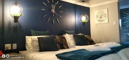 a bedroom with a large bed with a clock on the wall at Mitchell's Guesthouse in Parow