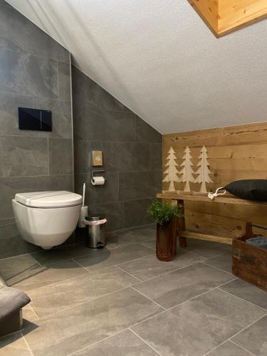 a bathroom with a toilet and a sink and a tub at Restaurant Hotel Schermtanne in Adelboden