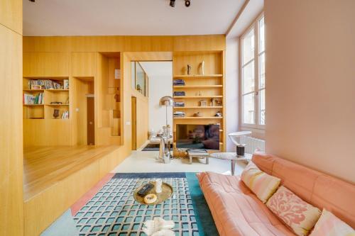 un salon avec un canapé et une grande fenêtre dans l'établissement Le Kube - Hyper centre de Bordeaux, à Bordeaux