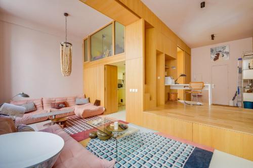 un salon avec un canapé rose et une table dans l'établissement Le Kube - Hyper centre de Bordeaux, à Bordeaux