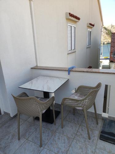 a table and two chairs on a patio at Apartments Katica in Metajna