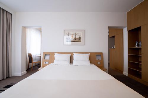 a bedroom with a large white bed in a room at Novotel Vilnius Centre in Vilnius