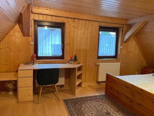 Cette chambre en bois comprend un bureau et un lit. dans l'établissement Haus Tannenzäpfle, à Waldachtal