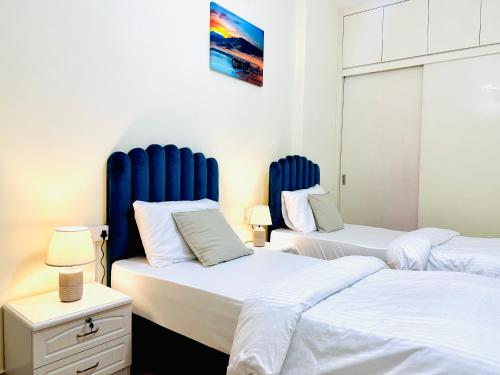 two beds with blue headboards in a room at VIP Hostel - Females Only in Dubai