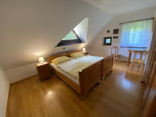 a bedroom with a bed and a window and a table at Country House Pri Lipet Žiri in Žiri
