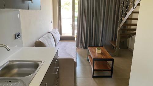 a kitchen and living room with a sink and a couch at Mystique Luxury Suites & Maisonettes in Laganas