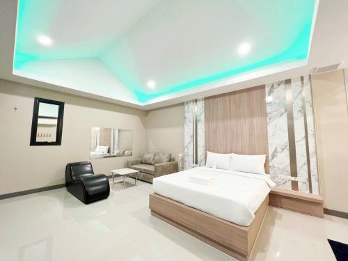 1 dormitorio con 1 cama y 1 silla en una habitación en โรงแรมในฝัน en Chon Buri