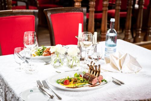 a table with two plates of food and wine glasses at Romantik Hotel Gutshaus Ludorf in Ludorf