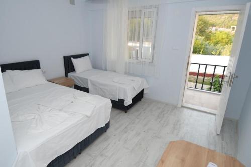 um quarto branco com 2 camas e uma janela em GREEN GARDEN ALLGAU HOTEL em Pamukkale