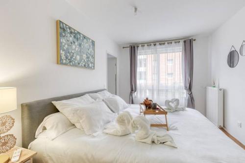 Un dormitorio con una cama con dos cisnes. en L'élégant T2 proche de Versailles et de Paris en Guyancourt