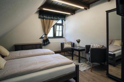 a bedroom with two beds and a table and a window at Stará Zvonica in Nižná Boca