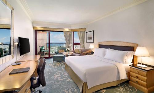 a hotel room with a bed and a desk with a computer at Jeddah Hilton in Jeddah