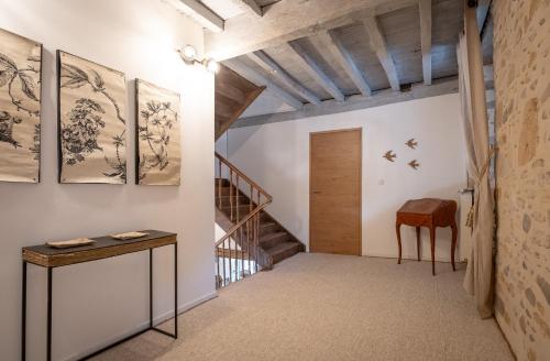a hallway with a staircase and a table and chairs at Ferme Sarthou in Lucq-de-Béarn