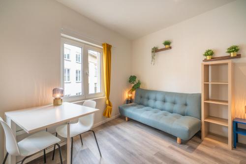 uma sala de estar com um sofá azul e uma mesa em Antwerp Center Cozy Cityflats em Antuérpia