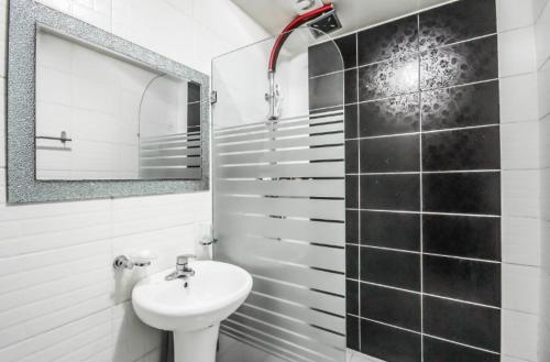 ein weißes Badezimmer mit einem Waschbecken und einem Spiegel in der Unterkunft Tongyeong V Motel in Tongyeong