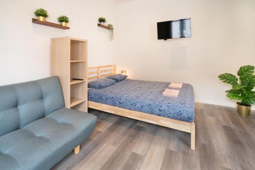 um quarto com uma cama, um sofá e uma televisão em Antwerp Center Cozy Cityflats em Antuérpia