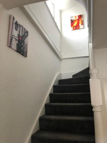a stairway with black steps and a window at Room with shared kitchen in Mill Hill