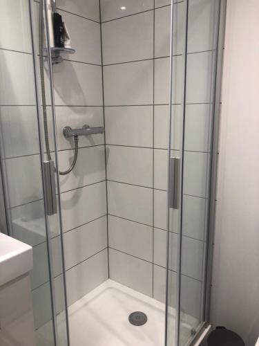 a shower with a glass door in a bathroom at Room with shared kitchen in Mill Hill