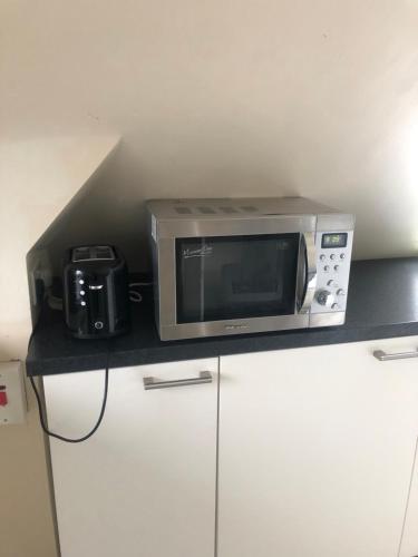 a microwave and a camera sitting on a counter at Room with shared kitchen in Mill Hill