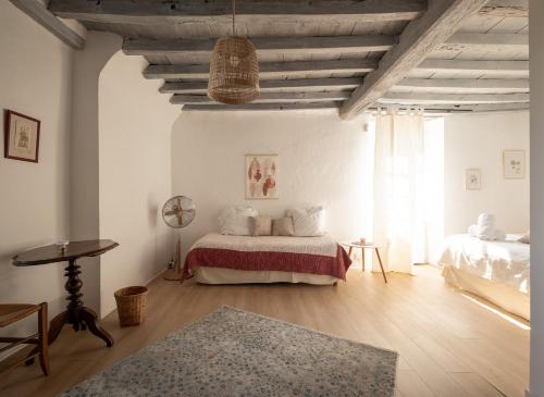 a white bedroom with a bed and a table at Ferme Sarthou in Lucq-de-Béarn