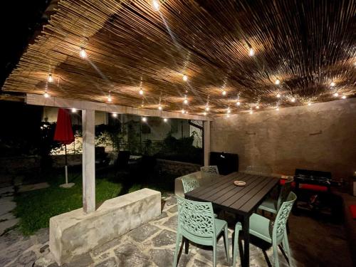 a patio with a wooden table and chairs and lights at Il Convento Ancient Apartment with private garden in Bellagio
