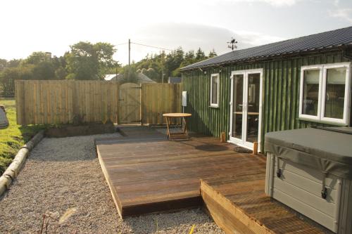 a backyard with a wooden deck next to a building at White Swan Inn in Belford