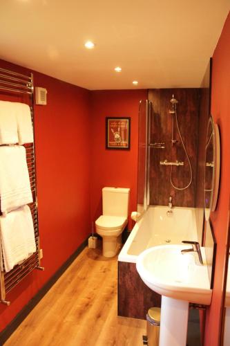uma casa de banho com uma banheira, um WC e um lavatório. em White Swan Inn em Belford