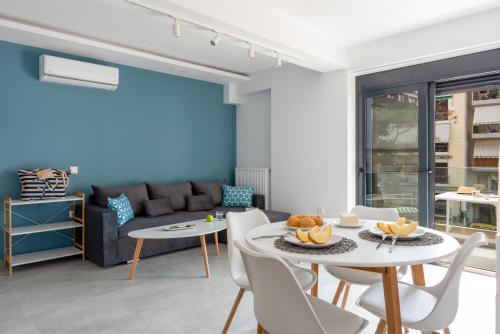 a living room with a couch and a table and chairs at PROPAN CITY SUITES in Volos