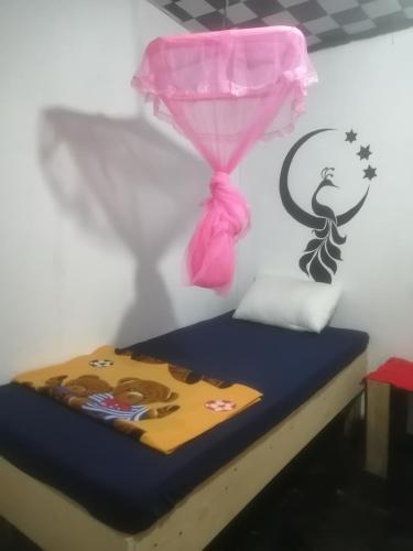a room with a bed with a pink curtain at Cozy House Hostel in Ella