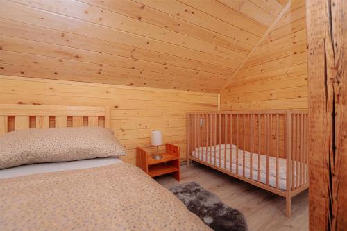 a bedroom with a bed in a wooden cabin at Chalúpka Lavender in Zázrivá