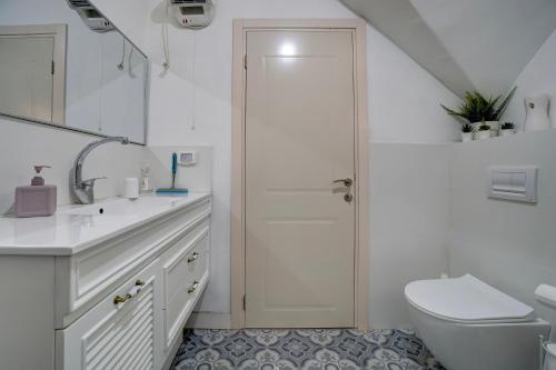 a white bathroom with a toilet and a sink at Amanda's place Central Modern spacious family APT in Zikhron Ya'akov