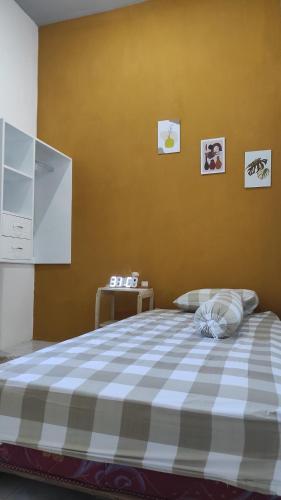 1 dormitorio con 1 cama con manta blanca y azul a cuadros en Babemhome, en Karanganyar
