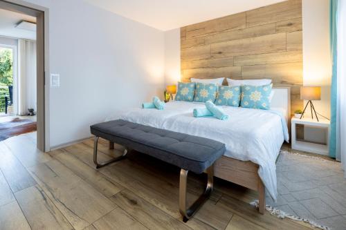 a bedroom with a large bed with blue pillows at Design Apartment-bis 4 Pers-Vollwertige Küche-Parkplatz-WiFi-Garten-Terrasse in Schiffweiler