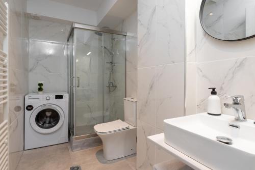 a bathroom with a washing machine and a washer at PROPAN CITY SUITES in Volos