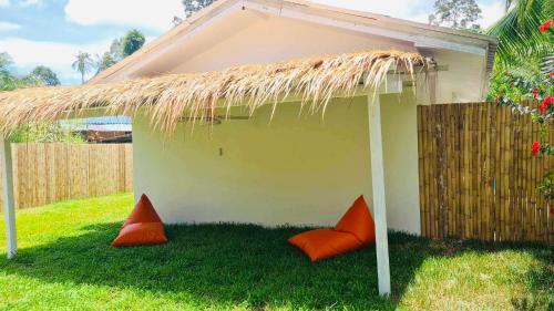 a small house with orange pillows in the grass at The Hideout Samui in Koh Samui 