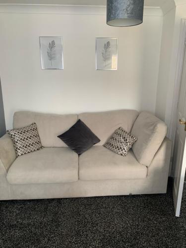 a couch in a living room with pillows on it at Witton House in Stockton-on-Tees