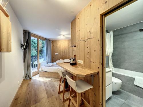 夏慕尼白朗峰的住宿－Le Caribou，客房设有书桌、床和浴室。