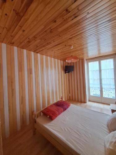 uma cama num quarto com uma parede de madeira em appartement 3 chambres em Cauterets