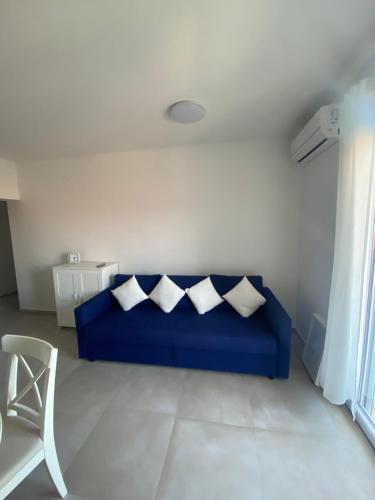 een blauwe bank met vier kussens in een woonkamer bij Apartmant Sea View in Poljica