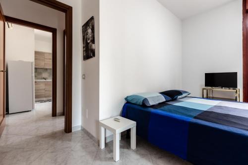 um quarto com uma cama, uma mesa e uma televisão em Quartu Sant'Elena - Roomy Apartment with Parking! em Su Forti